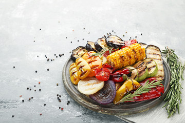 Grilled vegetable on brown cutting board with rosemary