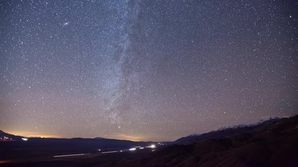 Wall Mural - Time lapse of the stars and Milky Way above a highway through the desert