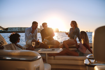 Wall Mural - Group of friends partying on yacht at sunset