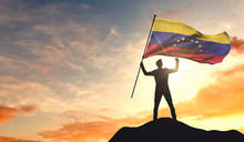 Venezuela Flag Being Waved By A Man Celebrating Success At The Top Of A Mountain. 3D Rendering