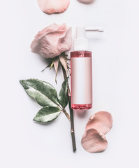 Wall Mural - pink roses essential cosmetic product bottle with branding mock up and rose flowers and petals on wh