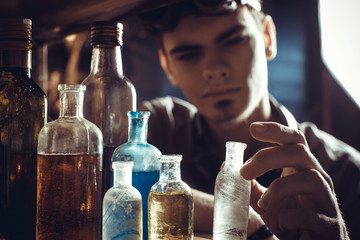 A young scientist chemist selects bottles for the experiment.