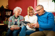 © didesign - Grandparents compare photos from youth with digital photos from granddaughter