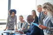 © Flamingo Images - Diverse businesspeople working together at a table in an office