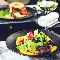 Poster - Tasty dish with juicy beef steak and fresh lettuce leaves at a restaurant, toned image