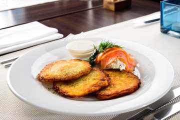 Canvas Print - Traditional Belarus potato pancakes (draniki) with sour cream in a plate at a cafe