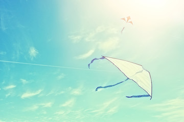 Wall Mural - Colorful kite flying in the blue sky through the clouds