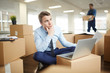 © pressmaster - Pensive businessman with paper sitting on the floor in front of laptop on top of packed box in new office
