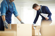 © pressmaster - Contemporary businessman in suit looking for necessary papers in one of boxes just after relocation to new office