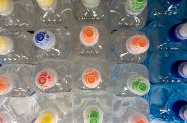 Wall Mural - PET Bottles. Image of many plastic bottles with water in a shop. plastic bottles with drinking water top view. 