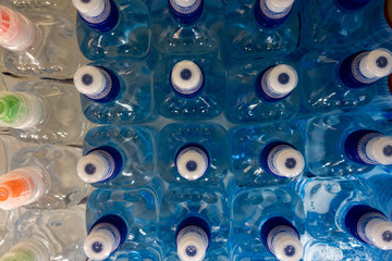 Wall Mural - PET Bottles. Image of many plastic bottles with water in a shop. plastic bottles with drinking water top view. 