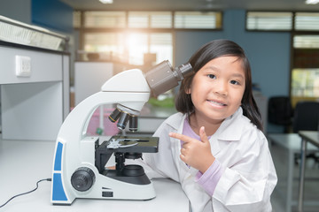 Wall Mural - cute asian scientist girl working with microscope
