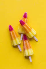 Wall Mural - Rocket shaped summer ice lolly on a bright yellow background