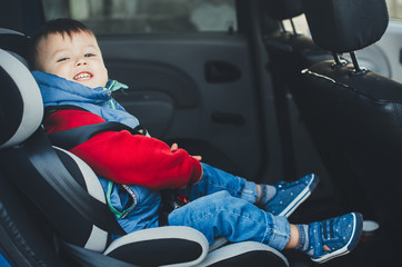 Adorable baby boy in safety car seat.