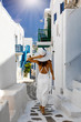 Frau im weißen Kleid erkundet Mykonos Stadt mit den weißgewaschenen Häusern und Gassen, Griechenland