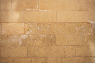 Wall Mural - Traditional weathered stone wall background in Malta