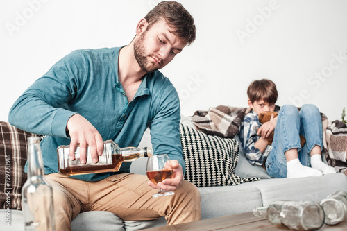 Cuadros en Lienzo Boy and father alcoholic social problems concept man pouring whiskey