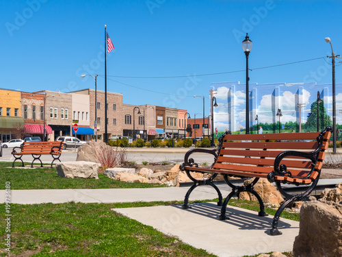 Cuadros en Lienzo Park bench in small town USA main street with commercial storefronts