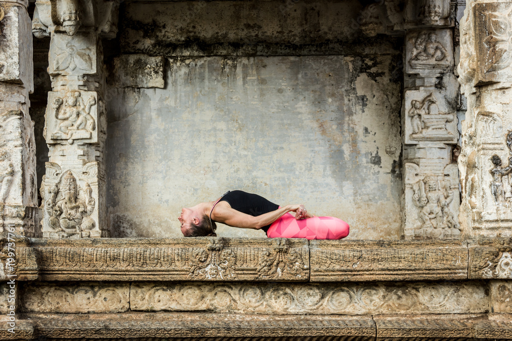 Yogi Woman In Matsyasana Pose With Pink Leggings And Hands Holding Feet yogi-woman-in-matsyasana-pose-with-pink-leggings-and-hands-holding-feet