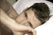 © Tony Marturano - Handsome, sexy good looking man with green eyes first thing in the morning, looking at camera in a bed with white sheets