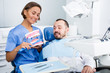 © JackF - Dentist in uniform with maket of jaw is telling about healthcare