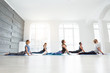 © uv_group - Group of adult people doing yoga cobra pose in studio class with big windows. Fitness, sport, training lifestyle concept.