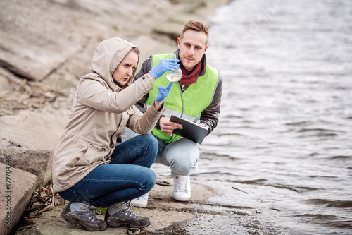 Fotomural Scientists or biologists working together on water analysis. .