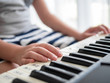 © nuiiko - Boy playing keyboard piano near window at home.