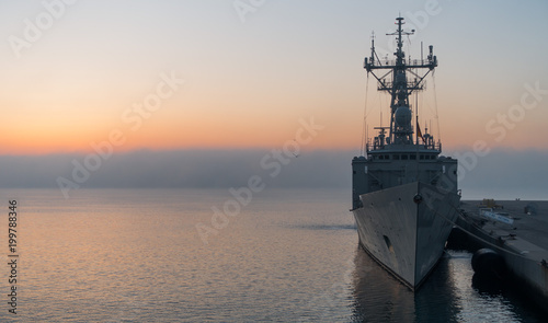 Fotografía A background of a war ship in the naval base during sunset