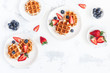 © Flaffy - Belgian waffles with fresh strawberry and blueberry on white background. Flat lay, top view, copy space