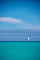  White sailboat against blue sky and sea, Antigua, Antigua and Baruda.