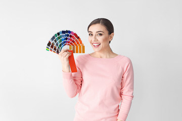 Wall Mural - Young woman with color palette on white background