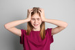© New Africa - Teenage girl suffering from headache on grey background