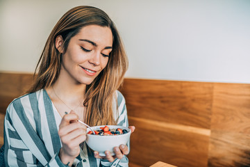 woman close up eating oat and fruits bowl for breakfast