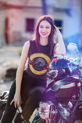 Wall Mural - pretty young woman smiling sitting on her motorbike. lifestyle concept