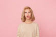 Bored to death! Young blonde female, feels drearily and looks above, shows her tongue with disgust. Isolated over pink background.
