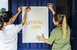 © Rawpixel.com - Women putting on store opening soon sign