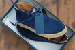 New mens shoes with blank price tag or label in a box. Male blue sneakers blank price tag or label close up in box, top view