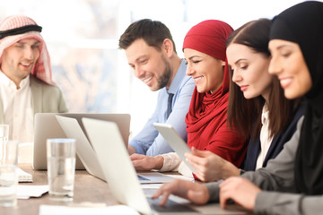 Canvas Print - Office employees and their Muslim coworkers having business meeting in office