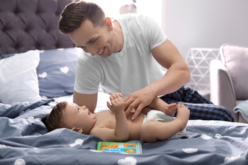 Canvas Print - Young father with his cute little son on bed