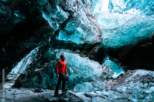 Fotografía adventurer inside a blue ice cave in iceland