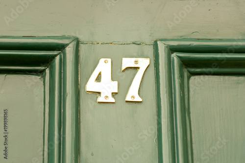 Poster House number 47 sign on green painted door