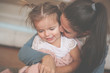 © Mladen - Mother enjoying with her daughter at home and hugging her.