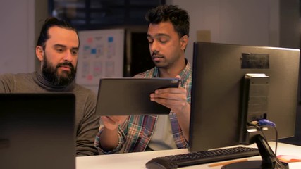 deadline, technology and people concept - programmers team with tablet pc computer working together late at night office