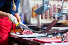 Woman In Butcher Shop Selling Meat Fillet On A Board