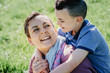 © nruedisueli - Happy mother and son holding each other and smiling outside on shiny day. Happy Mother's Day. Mom of a boy, happy family with small children.