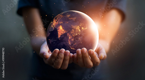 Fotografía Earth at night was holding in human hands