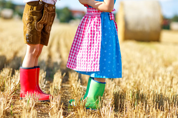 Two kids in traditional Bavarian costumes and red and green rubb