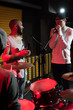 © Seventyfour - Modern young people performing in recording studio lit by red lights while making new album