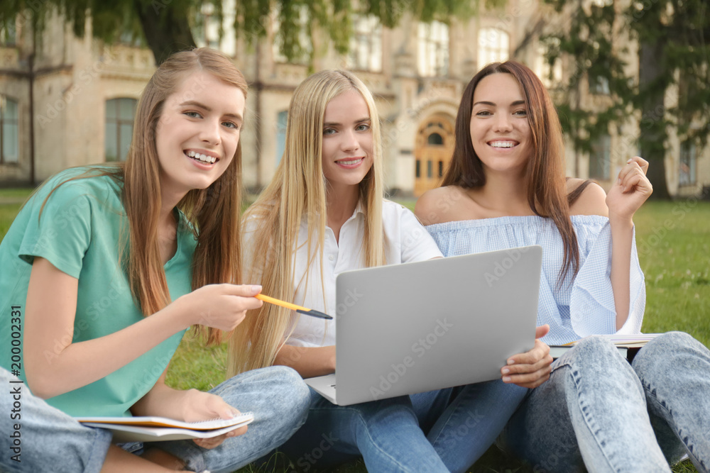 Young female students sitting in park